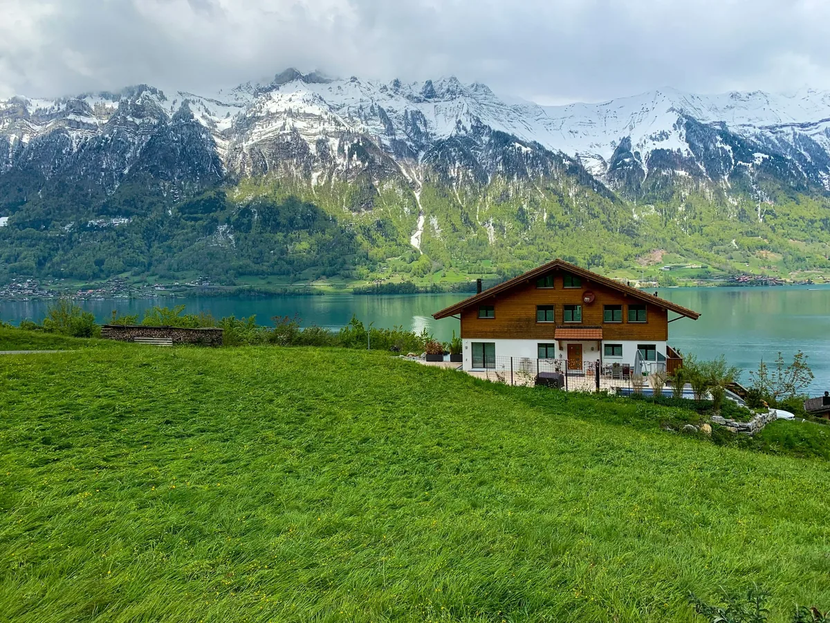 Schweizer Chalet mit Alpensee und schneebedeckten Bergen
